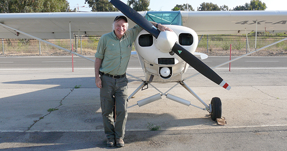 Bill Clark stands by prop plane on runway