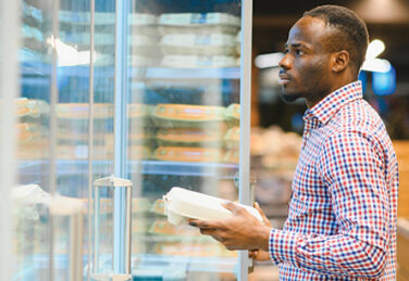 a shopper stands in the refrigerated egg section of the grocery store