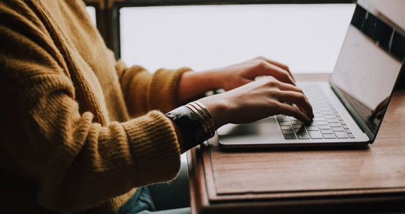 a female types on her laptop