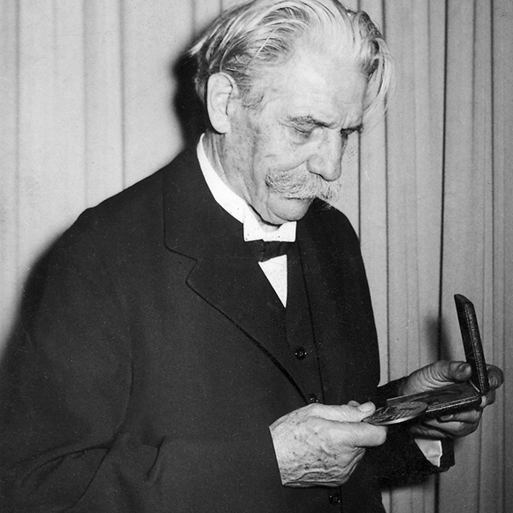 Dr. Schweitzer gazes down at the gold replica of AWI's Schweitzer Medal.