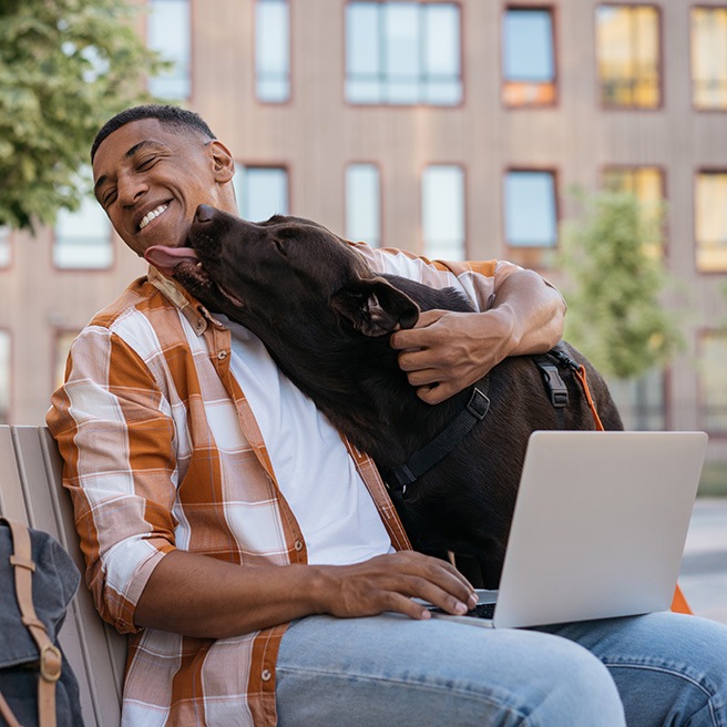 man with brown dog licking his chin