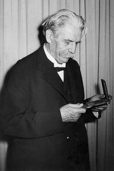 Dr. Schweitzer gazes down at the gold replica of AWI's Schweitzer Medal.