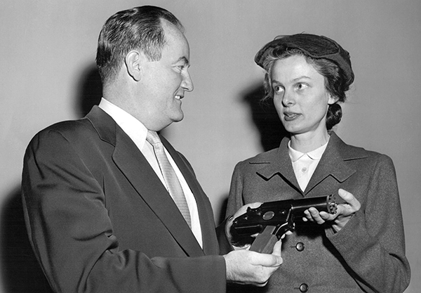 Christine Stevens shows Senator Hubert Humphrey a humane stunning device.