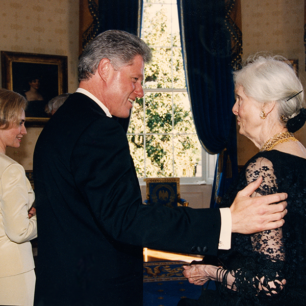 Bill Clinton and Christine Stevens converse while Hillary Rodham Clinton stands nearby.