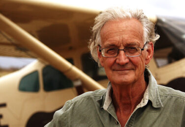 Dr. Iain Douglas-Hamilton standing in front of a propeller plane.