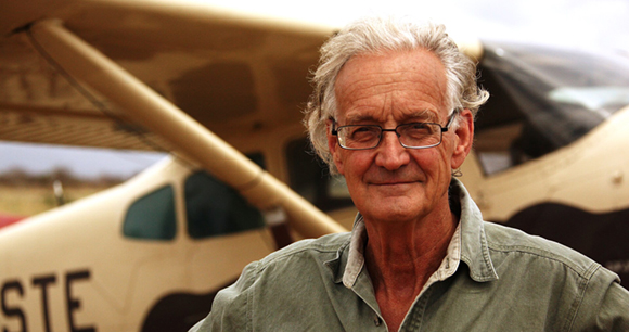 Dr. Iain Douglas-Hamilton standing in front of a propeller plane.