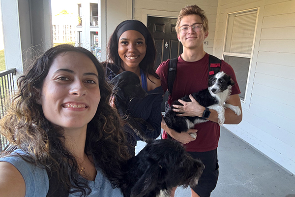 Madison Kossow, 2023 AWI Scholarship recipient, and friends hold adoptable puppies.