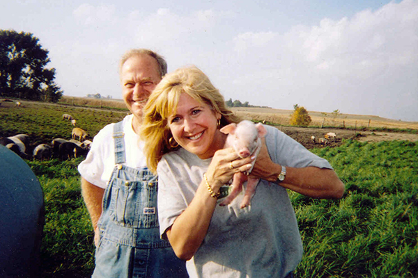Cathy Liss holds a tiny piglet.